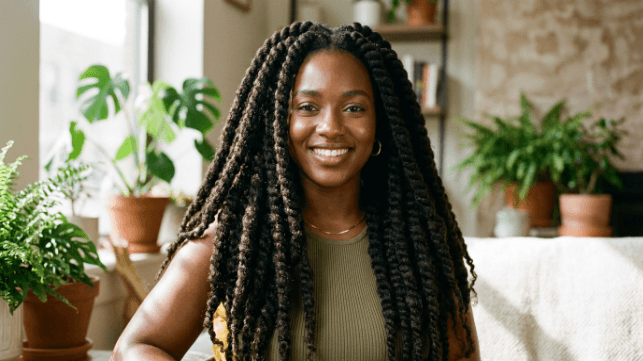 A woman with long, chunky Marley twists made from soft, matte, coily Marley hair that blends with natural Afro texture.