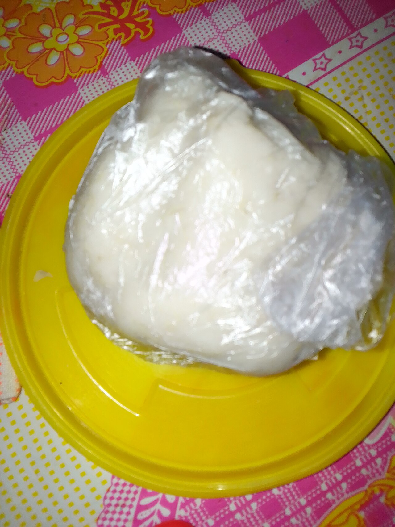 A smooth white mound of pounded yam beside a bowl of rich egusi soup
